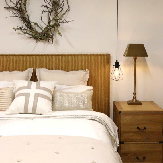 Bedroom with wooden headboard, lamp, and decorative wreath on wall