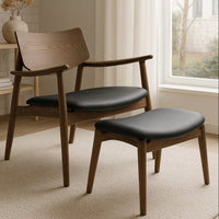 Wooden chair with black cushioned seat and ottoman in a room with a window and decor.