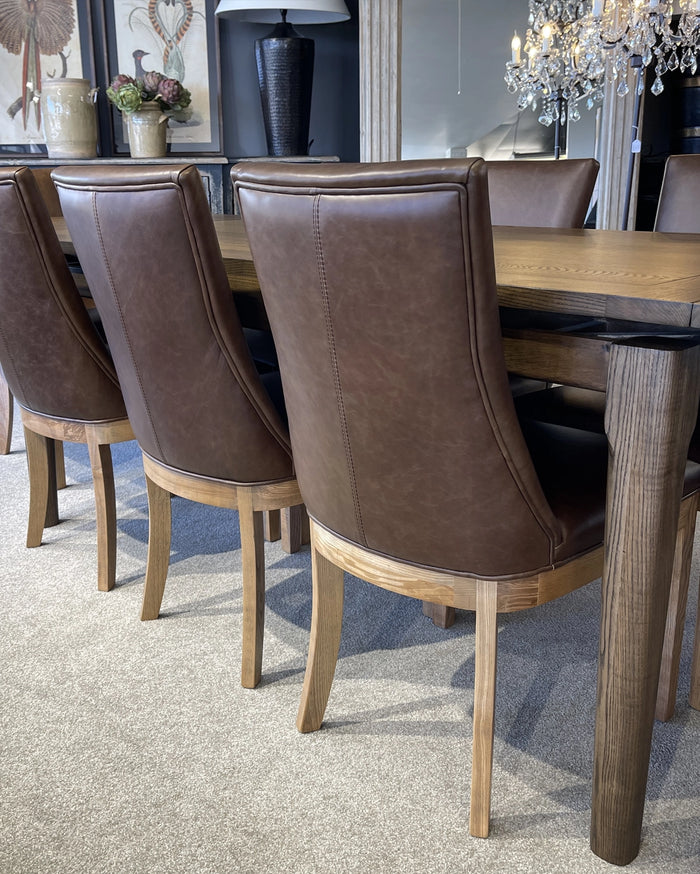 Dining room with brown leather chairs and a wooden table.