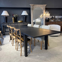 Dining room with a black table and chairs in a stylish interior setting.
