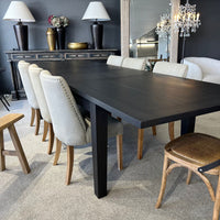 Dining room with a dark wooden table and chairs in a stylish interior.