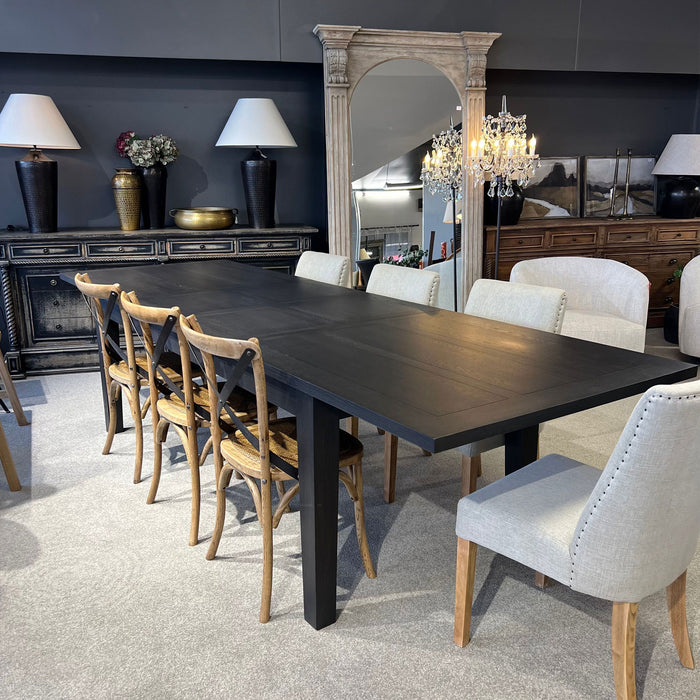 Dining room with a dark wooden table and various chairs, including a chandelier and decorative items.