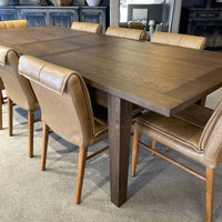 Dining table with brown leather chairs in a room setting