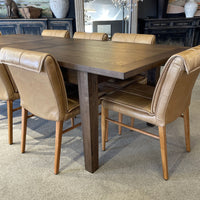 Dining table with brown chairs in a room setting