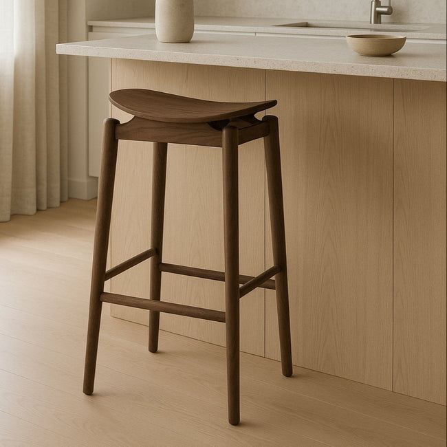 Wooden bar stool in a kitchen setting with light wood cabinets and a neutral color palette.